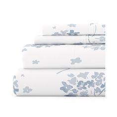 four sheets with blue flowers on them are folded in three different rows, one is white and the other is light blue