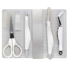 scissors and other tools are laying on a cutting board