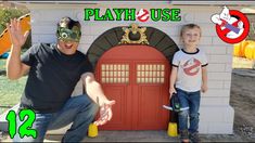 a man and boy sitting in front of a play house with fake props around them