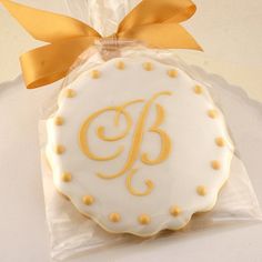 a decorated cookie with the letter b on it in a cellophane wrapper