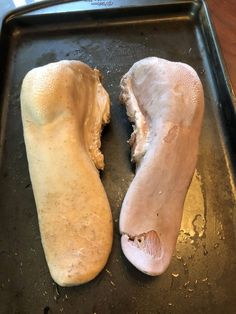 two pieces of bread sitting on top of a baking pan next to eachother