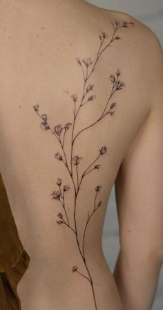 the back of a woman's body with small flowers on her left side,