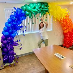 a woman standing in an office with balloons