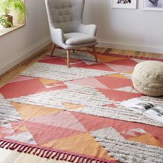 a living room with a chair, rug and pictures on the wall