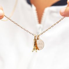 Keep a piece of Paris close to your heart with our Personalized Eiffel Tower Necklace. An iconic landmark in jewelry form, each necklace features a mini Eiffel Tower charm to pair with a shiny, engravable disc. Personalize with a special memory or a romantic dedication, with each disc being delicately hand-engraved and sent from the city of love itself.&nbsp;18K Champagne Gold Plated or 925 Sterling SilverCharms measure: 0.6 x 0.6 (Small Flat Disc), 0.7 x 0.2 (Eiffel Tower Charm Gold Plated), 0.5 x 0.2 (Eiffel Tower Charm Sterling Silver)Charms are removable from this chain and can be worn on all Merci Maman chain lengthsEngraved by hand in our Paris workshopSent with love in a complimentary gift boxPlease note that necklaces that have several charms may develop a certain patina, givin Charm Necklace With Round Pendant, Mini Eiffel Tower, Crystal Dice, Eiffel Tower Necklace, Paris Jewelry, City Of Love, Grandmother Gifts, Small Flat, Crystal Stars