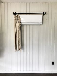 an air conditioner mounted to the side of a wall with clothes hanging on it