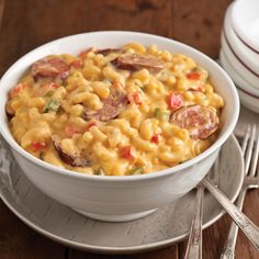 a white bowl filled with macaroni and cheese on top of a wooden table