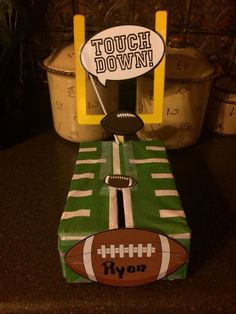 a green and white striped box with a football on it, sitting on a counter