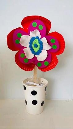 a paper plate flower in a pot with polka dots