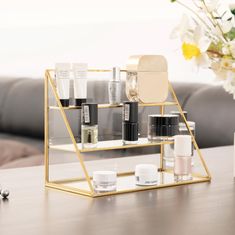 an assortment of beauty products sitting on a table next to a vase with flowers in it