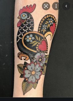 a tattoo on the arm of a person with a rooster and flowers in it's tail