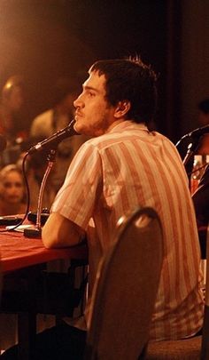 a man sitting at a table in front of a microphone