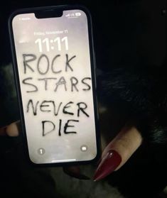 someone holding up a cell phone with the words rock stars never die written on it