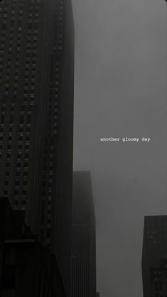 the words another gloomy day are written in foggy skies above tall buildings on a city street