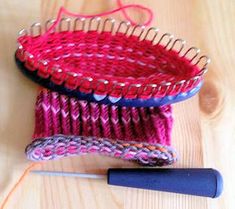 three knitted baskets sitting on top of a wooden table next to a crochet hook