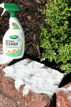 a bottle of cleaner sitting on top of a rock