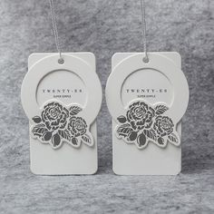 two white tags with black flowers on them