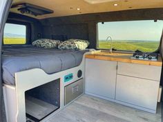 the interior of a camper with an oven and sink in it's bed