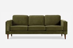 a green couch with wooden legs on a white background