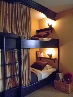 bunk beds in a room with curtains and lights on the wall, along with a basket full of items