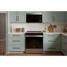 a kitchen with light blue cabinets and stainless steel appliance on the counter top