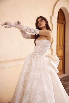 a woman in a white wedding dress and gloves