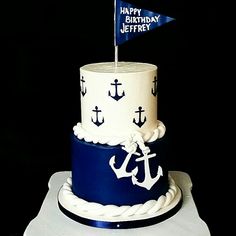 a blue and white birthday cake with an anchor on top