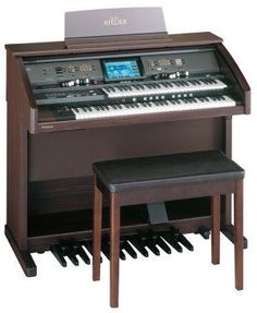 an electronic organ sitting on top of a wooden table next to a bench with two stools