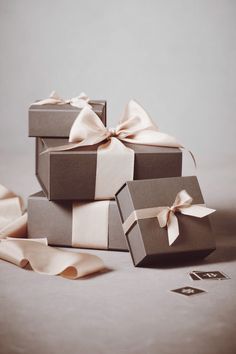 three boxes with bows are stacked on top of each other, one has a ribbon