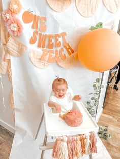 a baby sitting in a highchair with a cake on it's table