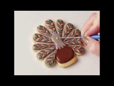 someone is decorating some cookies with icing