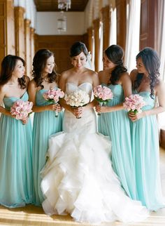 a group of women standing next to each other holding bouquets