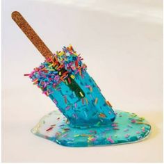 a blue cup with sprinkles and a wooden stick sticking out of it