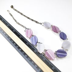 *Description: This is a beautiful Lisner necklace with Lucite leaves in lavender, pink, and white. The Lucite leaves are sitting on a rhodium plated base link. The silver tone necklace has three leaves of each color. The hook on the chain is signed Lisner. The color combination of pink, lavender, and white are beautiful and would make a great vintage gift or a wonderful addition to your vintage necklace collection. *Approximate Measurements: Length - 16 1/2 Inches *Condition: Great vintage condi Vintage Pink Oval Necklace, Vintage Round Purple Necklace, Vintage Lavender Round Jewelry, Vintage Lavender Jewelry, Vintage Purple Round Necklace, Leaf Necklace Silver, Leaves Necklace, Formal Earrings, Lavender Pink