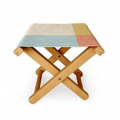 a small wooden stool with multicolored stripes on the top and bottom, sitting in front of a white background