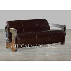 a brown leather couch sitting on top of a wooden floor