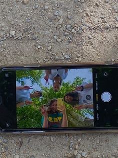 a cell phone is laying on the ground with several people taking pictures in front of it