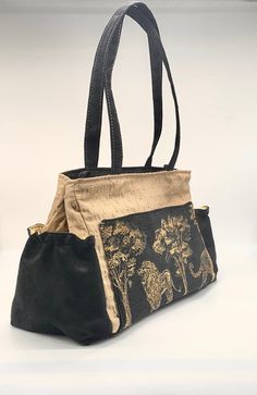 "Black and gold vegan handbag with lion tapestry. 2 handles to wear over the shoulder and a removable long handle to wear as a cross body. 13\" wide 9\" high 6 \" base . 2 inside pockets 1 outside pocket with sewn in magnet 2 side pockets to hold umbrella and water bottle." Elegant Tote Bag With Pockets, Elegant Daily Use Bags With Pockets, Elegant Tote Shoulder Bag With Pockets, Luxury Tote Shoulder Bag With Pockets, Luxury Shoulder Bag Tote With Pockets, Elegant Everyday Satchel With Pockets, Elegant Rectangular Shoulder Bag With Pockets, Elegant Daily Use Satchel With Pockets, Formal Rectangular Bags With Pockets