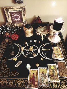 a table topped with tarot cards, candles and other items on top of it