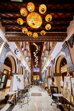 the inside of a building with many paintings on the walls and ceiling lights hanging from the ceiling