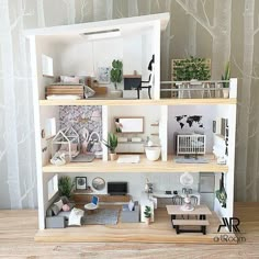 a doll house with furniture and decorations on the shelves