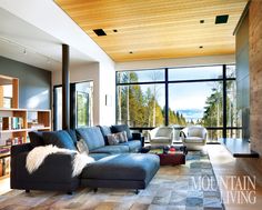 a living room filled with furniture next to a large window covered in lots of windows