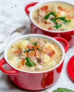 two red pots filled with soup on top of a table