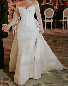 a bride and groom hold hands as they walk down the aisle