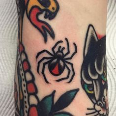 a close up of a person's leg with tattoos on it and a spider