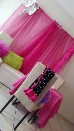 a living room filled with furniture and pink curtains