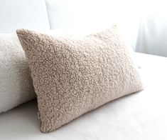 two pillows sitting on top of a white couch