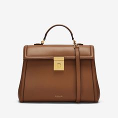 A larger iteration of The Paris, The Midi  Paris is a cosmopolitan top handle bag that showcases our unwavering commitment to craftsmanship. Each one is ethically handmade from sustainable Italian leather and is exquisitely framed with a bombée trim. It features a new trunk inspired gold-plated lock, as well as a detachable and adjustable leather strap for further styling options. The soft cotton-lined interior is capacious enough for all daily essentials. The  Midi   Paris is inspired by the timeless elegance of the City of Light. Leather Top Handle Bag, Quiet Luxury Handbags, Aw24 Outfits, Demellier Bag, Winter Handbag, London Bags, Card Holder Purse, Work Tote Bag, Best Wallet