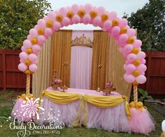 a pink and yellow birthday party with balloons on the bed, curtains and table cloths