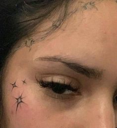 a close up of a person's face with stars on their forehead and behind her ear